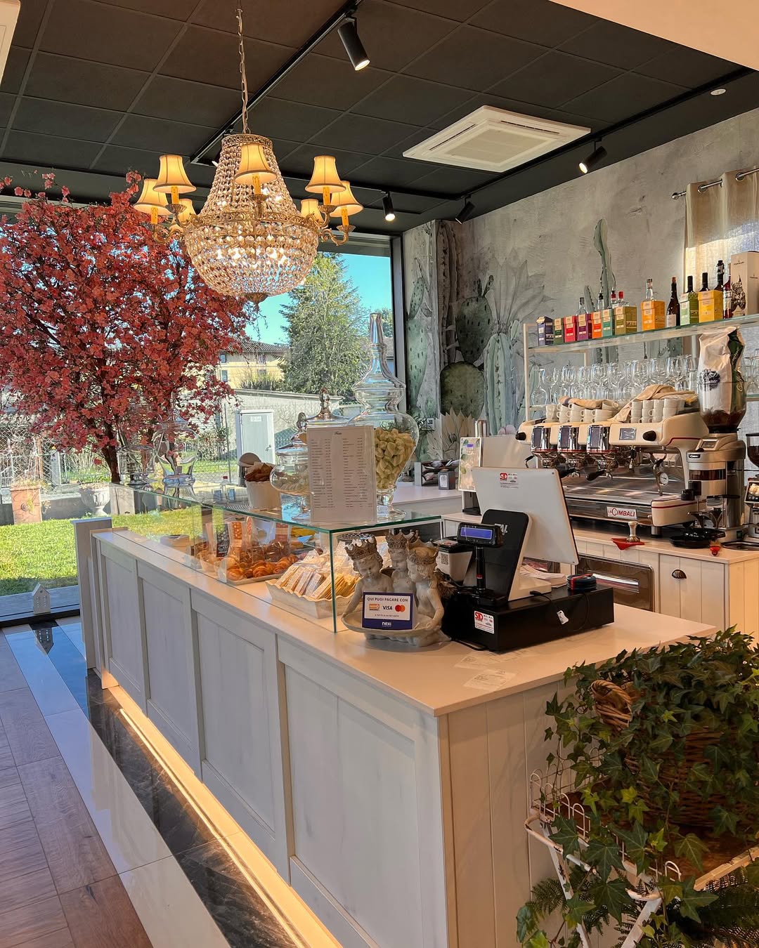 Bancone Frida con lampadario di cristallo e albero dai toni autunnali